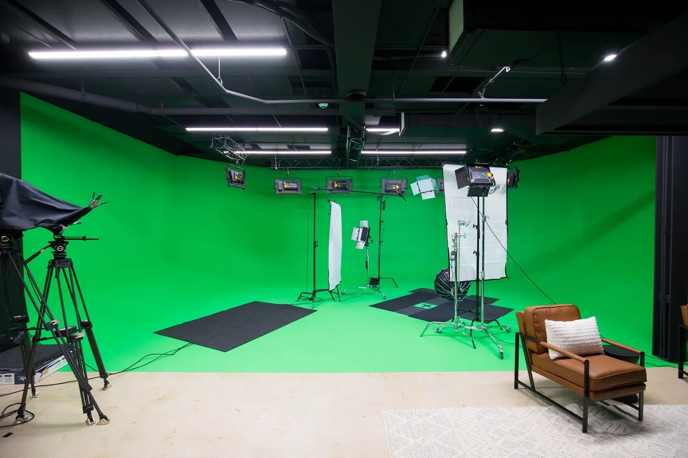 Green screen cyclorama with lighting rig and lounge chair